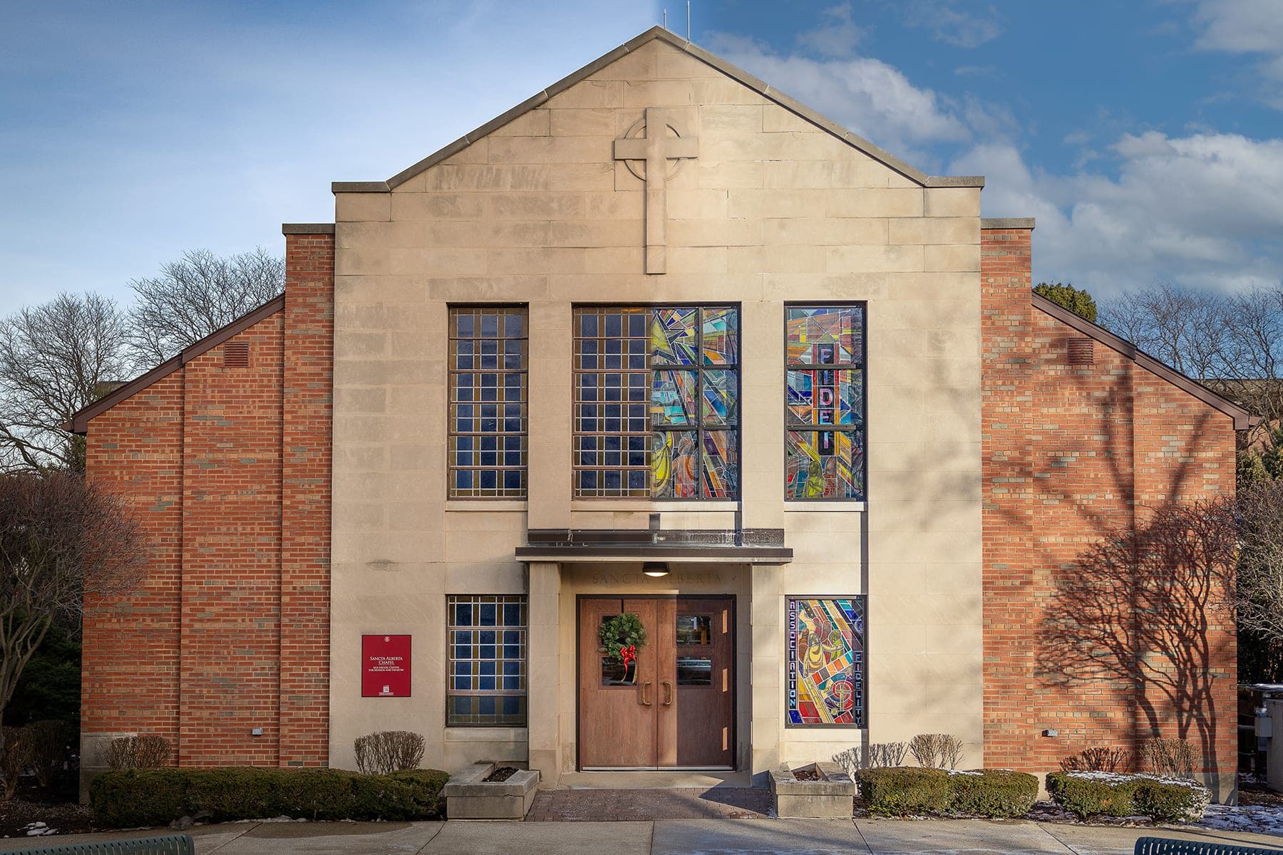 Lewis University chapel with stained-glass windows under a blue sky