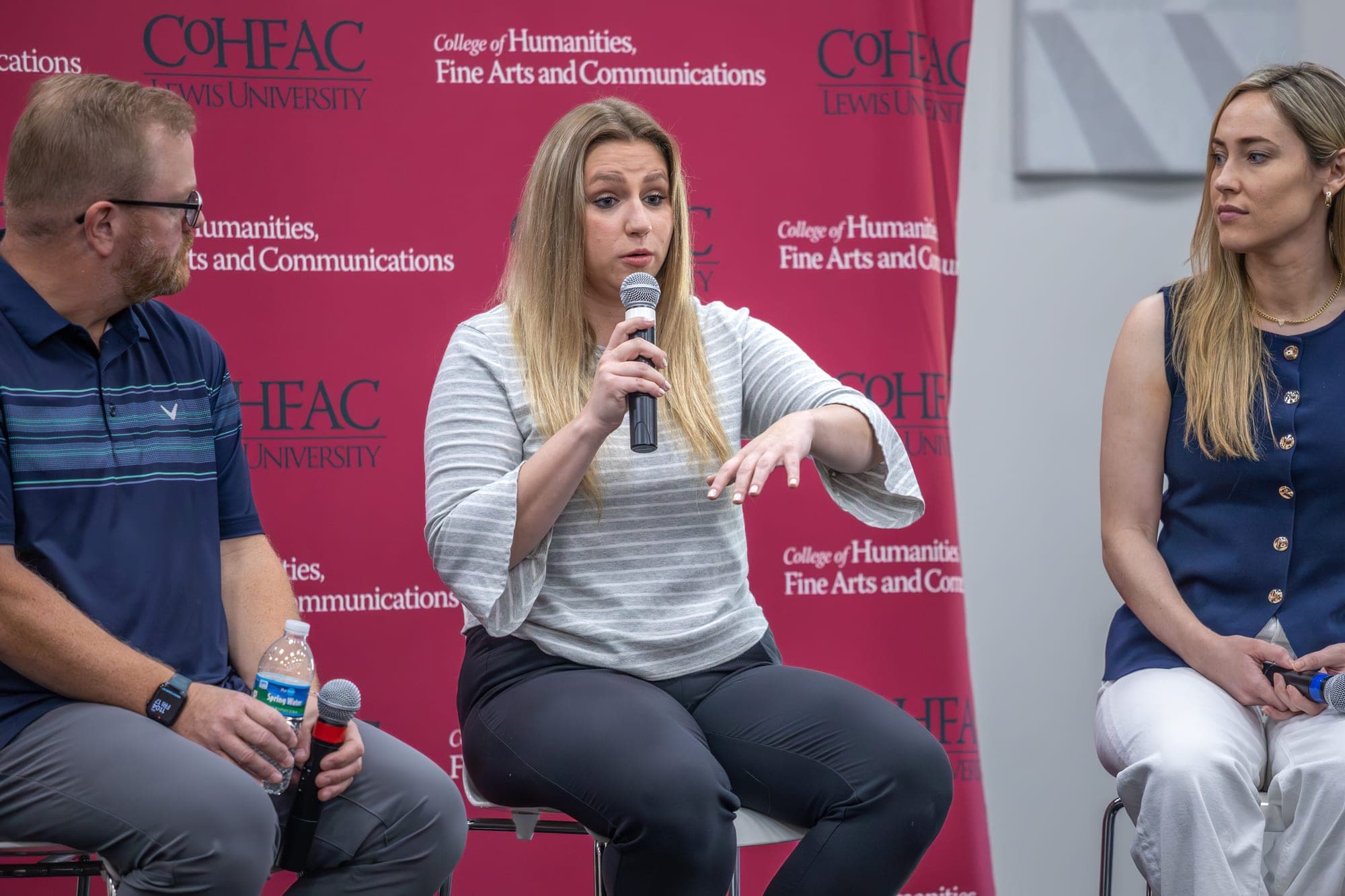 Panel discussion on stage at a College of Humanities, Fine Arts and Communications event