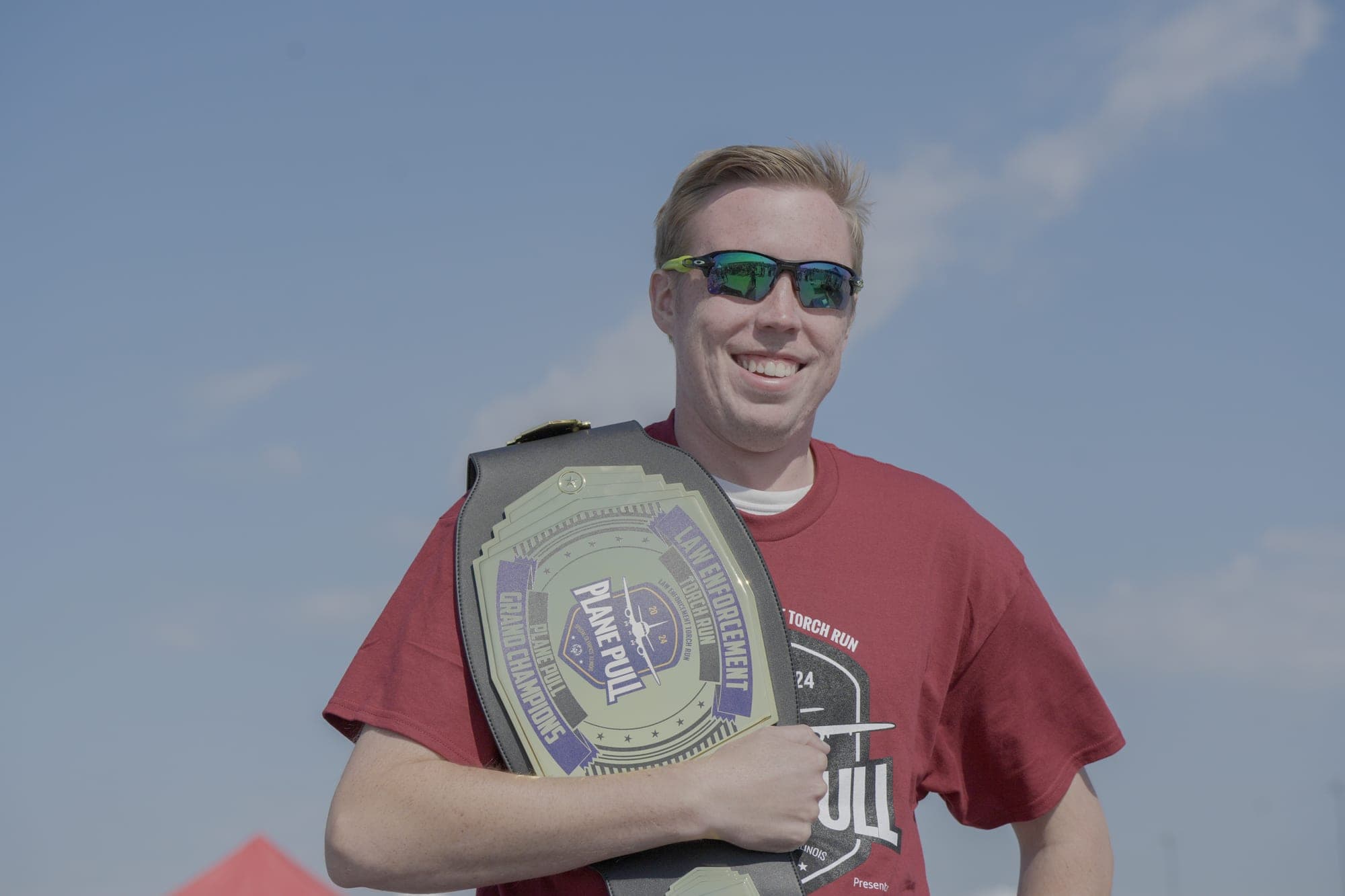 Logan Kap holding the Plane Pull championship belt